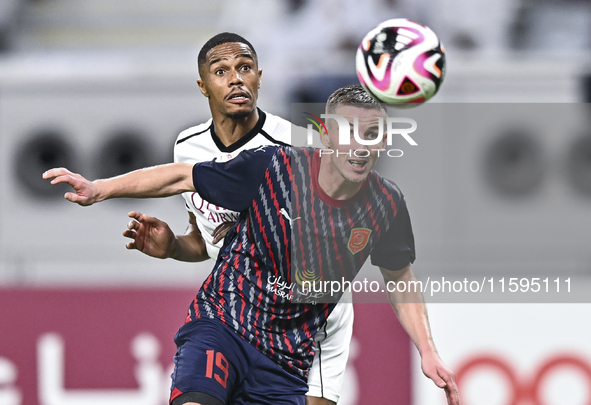 Pedro Miguel Correia (L) of Al-Sadd SC battles for the ball with Benjamin Bourigeaud (R) of Duhail SC during the Ooredoo Qatar Stars League...