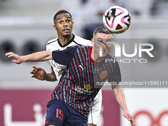 Pedro Miguel Correia (L) of Al-Sadd SC battles for the ball with Benjamin Bourigeaud (R) of Duhail SC during the Ooredoo Qatar Stars League...