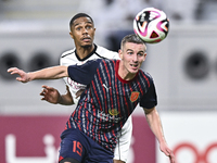 Pedro Miguel Correia (L) of Al-Sadd SC battles for the ball with Benjamin Bourigeaud (R) of Duhail SC during the Ooredoo Qatar Stars League...