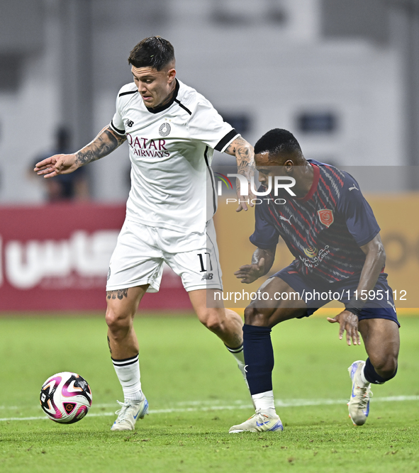 Cristo Ramon Gonzalez Perez (L) of Al-Sadd SC battles for the ball with Ismail Mohamad (R) of Duhail SC during the Ooredoo Qatar Stars Leagu...