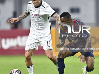 Cristo Ramon Gonzalez Perez (L) of Al-Sadd SC battles for the ball with Ismail Mohamad (R) of Duhail SC during the Ooredoo Qatar Stars Leagu...