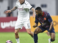 Cristo Ramon Gonzalez Perez (L) of Al-Sadd SC battles for the ball with Ismail Mohamad (R) of Duhail SC during the Ooredoo Qatar Stars Leagu...