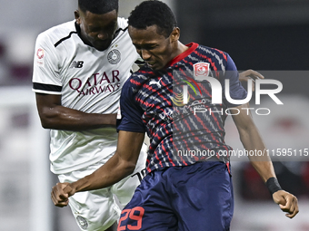 Musaab Khidir Mohamed (L) of Al-Sadd SC battles for the ball with Rashid Abdullah (R) of Duhail SC during the Ooredoo Qatar Stars League 24/...