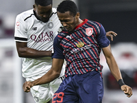 Musaab Khidir Mohamed (L) of Al-Sadd SC battles for the ball with Rashid Abdullah (R) of Duhail SC during the Ooredoo Qatar Stars League 24/...