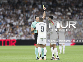 Kylian Mbappe of Real Madrid receives a yellow card during the La Liga 2024/25 match between Real Madrid and Espanyol at Santiago Bernabeu S...