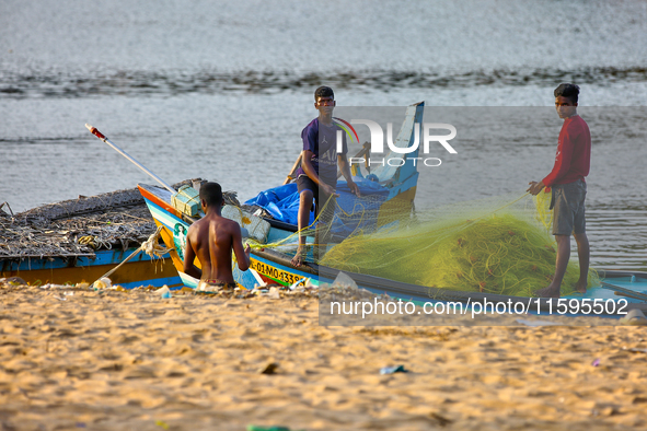 Fishermen untangle fishing nets along Paruthiyoor Beach in Paruthiyoor, Kerala, India, on April 15, 2024. 