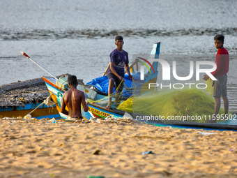 Fishermen untangle fishing nets along Paruthiyoor Beach in Paruthiyoor, Kerala, India, on April 15, 2024. (