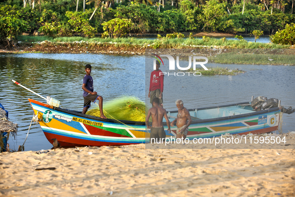 Fishermen load nets into a fishing boat along Paruthiyoor Beach in Paruthiyoor, Kerala, India, on April 15, 2024. 