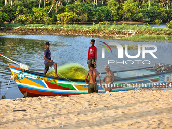 Fishermen load nets into a fishing boat along Paruthiyoor Beach in Paruthiyoor, Kerala, India, on April 15, 2024. (