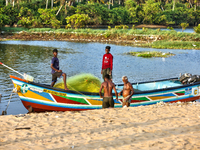 Fishermen load nets into a fishing boat along Paruthiyoor Beach in Paruthiyoor, Kerala, India, on April 15, 2024. (