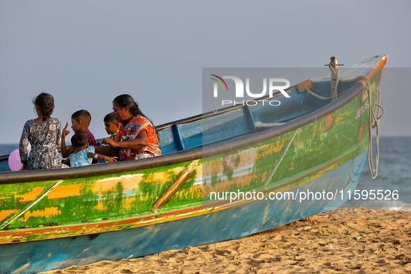 People sit in a fishing boat along Paruthiyoor Beach in Paruthiyoor, Kerala, India, on April 15, 2024. 