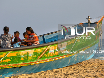 People sit in a fishing boat along Paruthiyoor Beach in Paruthiyoor, Kerala, India, on April 15, 2024. (