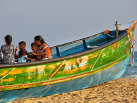 People sit in a fishing boat along Paruthiyoor Beach in Paruthiyoor, Kerala, India, on April 15, 2024. (