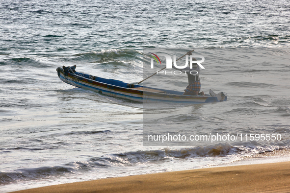 A fisherman paddles a fishing boat into the ocean along Paruthiyoor Beach in Paruthiyoor, Kerala, India, on April 15, 2024. 