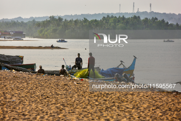 Fishermen untangle fishing nets along Paruthiyoor Beach in Paruthiyoor, Kerala, India, on April 15, 2024. 