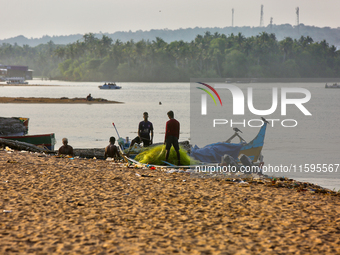 Fishermen untangle fishing nets along Paruthiyoor Beach in Paruthiyoor, Kerala, India, on April 15, 2024. (