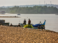 Fishermen untangle fishing nets along Paruthiyoor Beach in Paruthiyoor, Kerala, India, on April 15, 2024. (