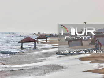 Fishermen push a fishing boat into the ocean along Paruthiyoor Beach in Paruthiyoor, Kerala, India, on April 15, 2024. (