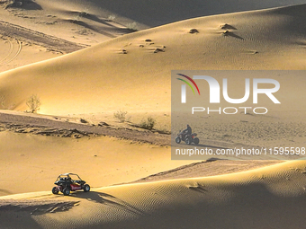 Tourists drive desert motorcycles through the Badain Jaran Desert at the Jinshawan Desert Tourism holiday camp in Zhangye, China, on Septemb...