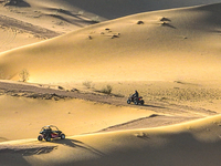 Tourists drive desert motorcycles through the Badain Jaran Desert at the Jinshawan Desert Tourism holiday camp in Zhangye, China, on Septemb...