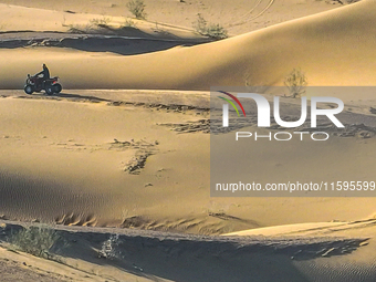 Tourists drive desert motorcycles through the Badain Jaran Desert at the Jinshawan Desert Tourism holiday camp in Zhangye, China, on Septemb...