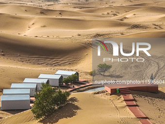 Tourists view the desert scenery at Jinshawan Desert tourism holiday camp in Zhangye, China, on September 21, 2024. (