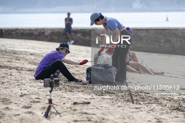 Several volunteers collect waste and garbage during a beach cleanup day in the municipality of Alges in Lisbon, Portugal, on September 21, 2...