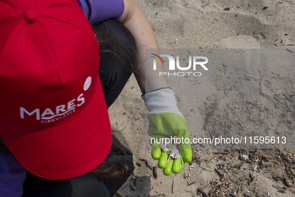 A volunteer collects waste and garbage during a beach cleanup day in the municipality of Alges, Lisbon, Portugal, on September 21, 2024. The...