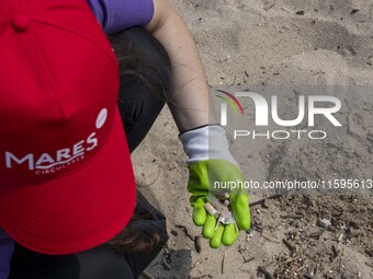 A volunteer collects waste and garbage during a beach cleanup day in the municipality of Alges, Lisbon, Portugal, on September 21, 2024. The...