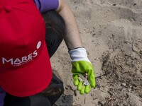 A volunteer collects waste and garbage during a beach cleanup day in the municipality of Alges, Lisbon, Portugal, on September 21, 2024. The...