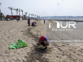 Several volunteers collect waste and garbage during a beach cleanup day in the municipality of Alges in Lisbon, Portugal, on September 21, 2...