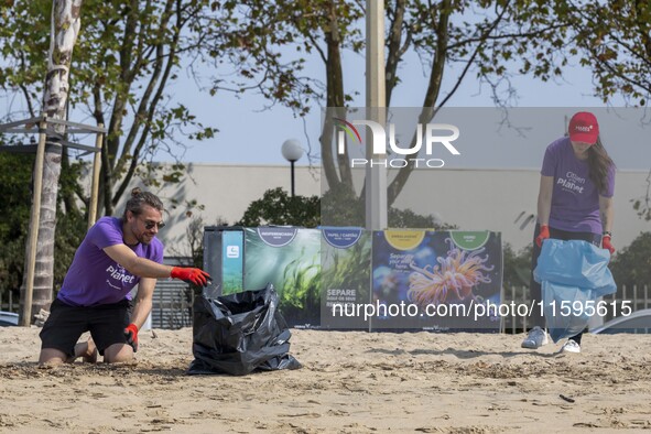 Several volunteers collect waste and garbage during a beach cleanup day in the municipality of Alges in Lisbon, Portugal, on September 21, 2...