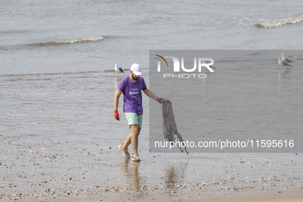 A volunteer collects waste and garbage during a beach cleanup day in the municipality of Alges, Lisbon, Portugal, on September 21, 2024. The...