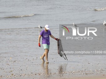 A volunteer collects waste and garbage during a beach cleanup day in the municipality of Alges, Lisbon, Portugal, on September 21, 2024. The...