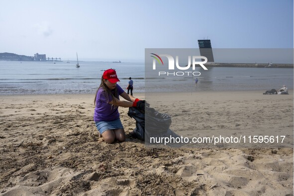 A volunteer collects waste and garbage during a beach cleanup day in the municipality of Alges, Lisbon, Portugal, on September 21, 2024. The...