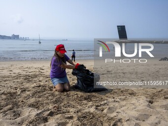 A volunteer collects waste and garbage during a beach cleanup day in the municipality of Alges, Lisbon, Portugal, on September 21, 2024. The...