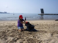 A volunteer collects waste and garbage during a beach cleanup day in the municipality of Alges, Lisbon, Portugal, on September 21, 2024. The...