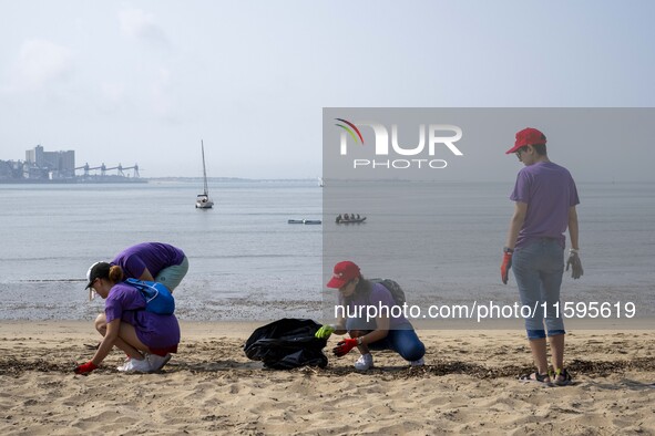 Several volunteers collect waste and garbage during a beach cleanup day in the municipality of Alges in Lisbon, Portugal, on September 21, 2...