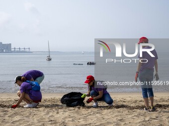 Several volunteers collect waste and garbage during a beach cleanup day in the municipality of Alges in Lisbon, Portugal, on September 21, 2...