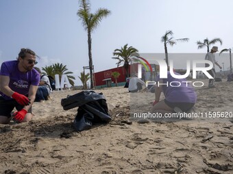 Several volunteers collect waste and garbage during a beach cleanup day in the municipality of Alges in Lisbon, Portugal, on September 21, 2...