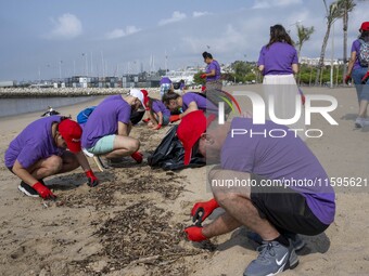 Several volunteers collect waste and garbage during a beach cleanup day in the municipality of Alges in Lisbon, Portugal, on September 21, 2...