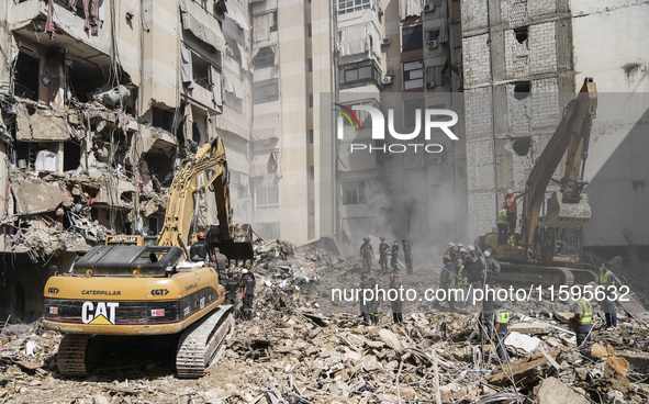 Rescuers sift through the rubble at the scene of an Israeli strike that targets Beirut's southern suburbs, as search and rescue operations c...