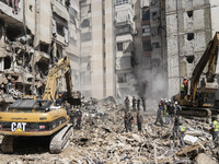 Rescuers sift through the rubble at the scene of an Israeli strike that targets Beirut's southern suburbs, as search and rescue operations c...