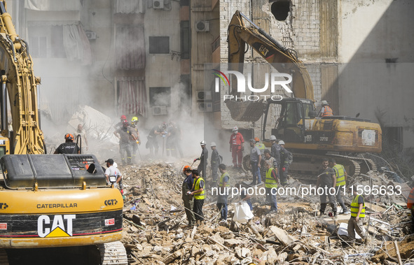 Rescuers sift through the rubble at the scene of an Israeli strike that targets Beirut's southern suburbs, as search and rescue operations c...