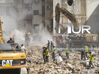 Rescuers sift through the rubble at the scene of an Israeli strike that targets Beirut's southern suburbs, as search and rescue operations c...