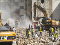 Rescuers sift through the rubble at the scene of an Israeli strike that targets Beirut's southern suburbs, as search and rescue operations c...