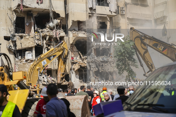 Rescuers sift through the rubble at the scene of an Israeli strike that targets Beirut's southern suburbs, as search and rescue operations c...