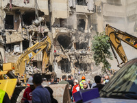 Rescuers sift through the rubble at the scene of an Israeli strike that targets Beirut's southern suburbs, as search and rescue operations c...