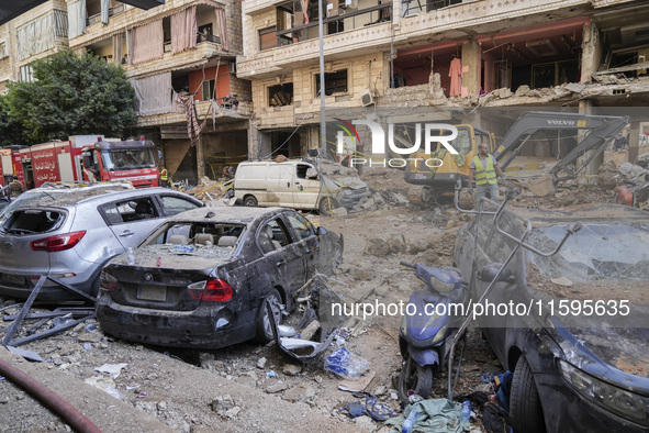 Rescuers sift through the rubble at the scene of an Israeli strike that targets Beirut's southern suburbs, as search and rescue operations c...