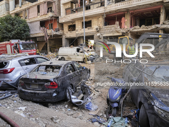 Rescuers sift through the rubble at the scene of an Israeli strike that targets Beirut's southern suburbs, as search and rescue operations c...